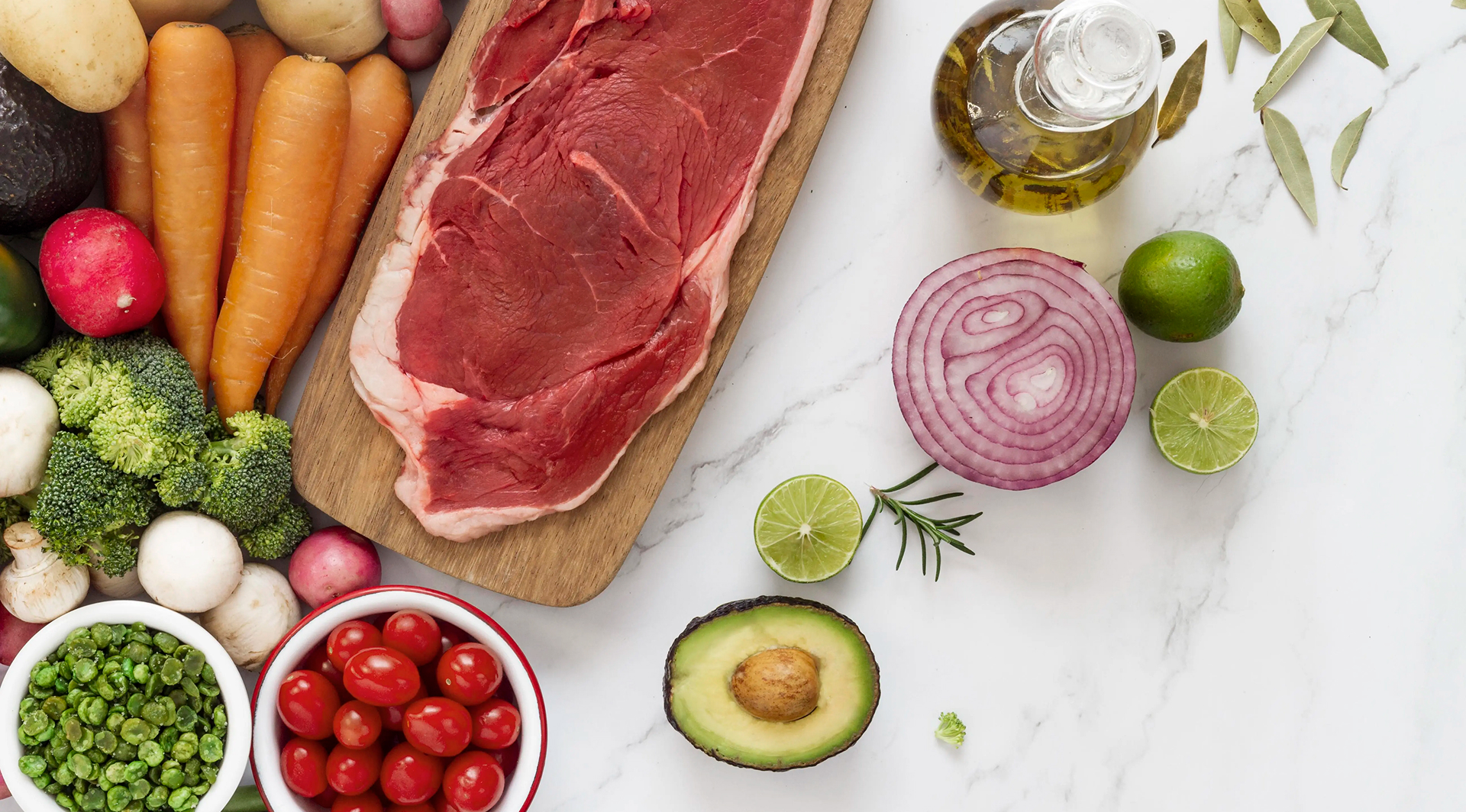 Pièce de bœuf crue avec légumes frais, avocat, citron vert et huile d’olive